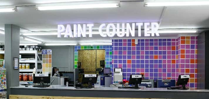 a shop counter with paint counter displayed in fluorescent lights